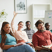 Small group of diverse adults engaging in a training class in a white room.