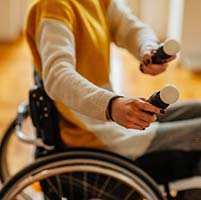 Person in a wheelchair holding video game controllers