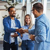 Decorative image of group of people which includes two men shaking hands.