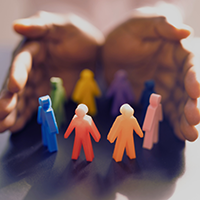 Decorative image of two hands holding colorful people-shaped figures.