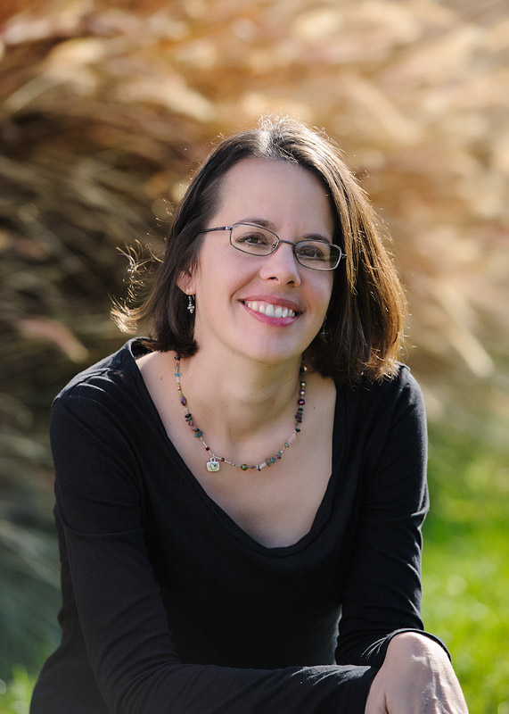 Picture of woman with dark hair, glasses, and smiling.