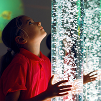 Young girl with color therapy light.